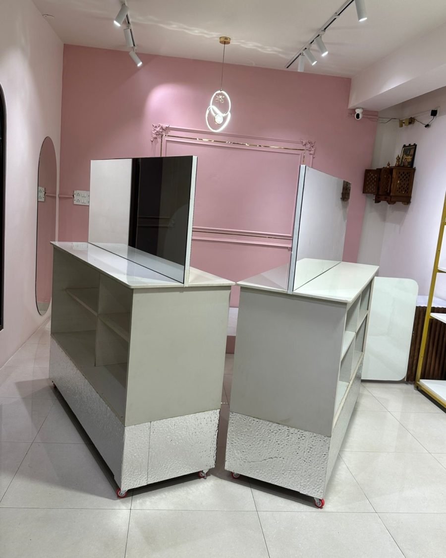 The display counters of the Ananta Designs boutique seen at an angle, with the pink feature wall and pendant light behind.