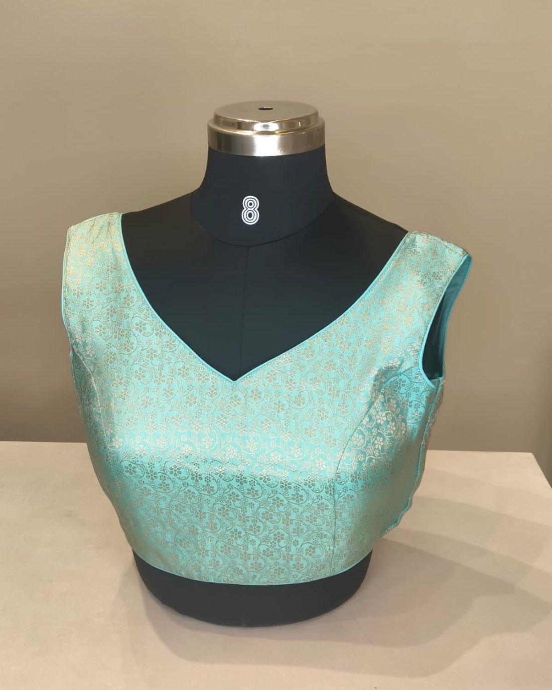 Mint Green Brocade V Neck Blouse photographed on a dress form at the Ananta Designs boutique
