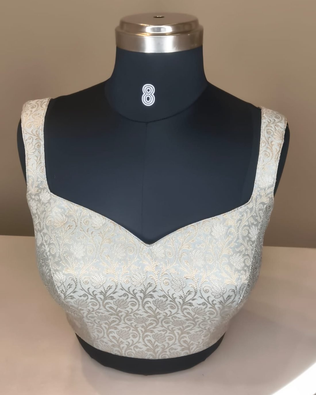 White Silver Brocade Blouse photographed on a dress form at the Ananta Designs boutique