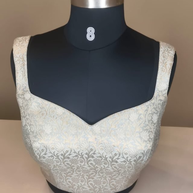 White Silver Brocade Blouse photographed on a dress form at the Ananta Designs boutique